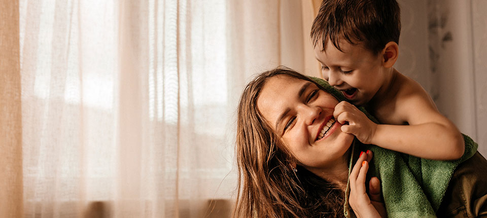 Woman gives her child a piggyback ride. Here are hypertension symptoms in women to know.