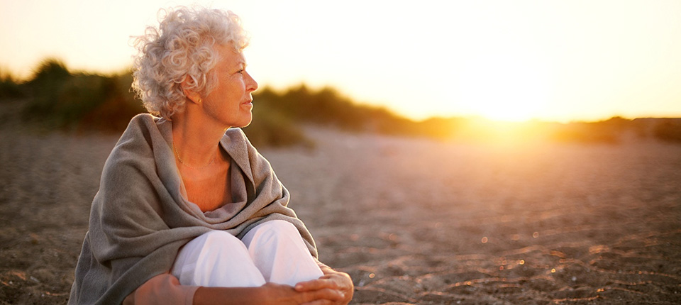 Old woman sitting on the beach looking away at copyspace. Senior female sitting outdoors; Shutterstock ID 186030296; PO: 123