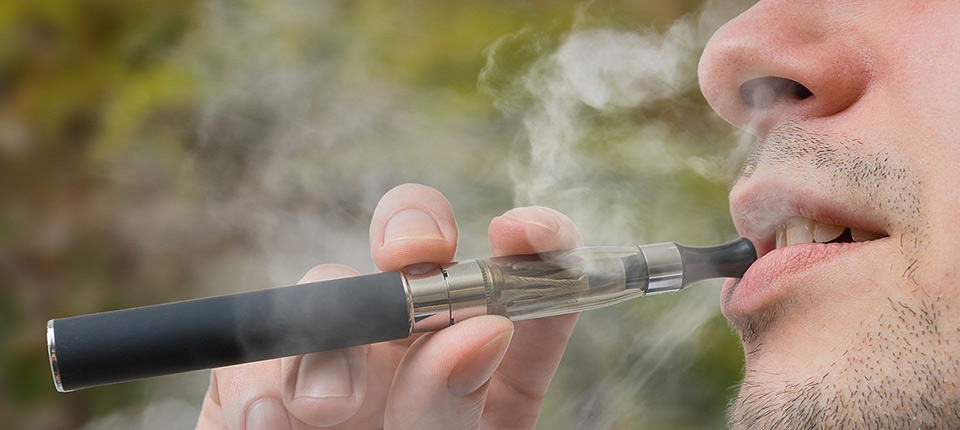 Young smoker is vaping e-cigarette or vaporizer.